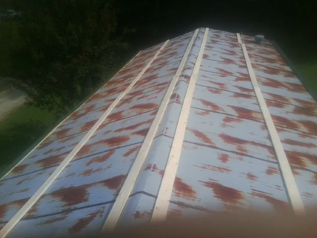 Rusted metal roof panels with new wood purlins before replacement — Storm Damage Roof Repair in Chataignier by Roofing Brothers